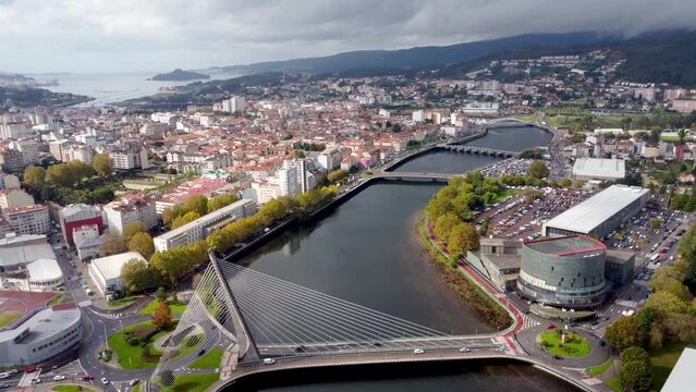 Cinematic aerial perspective of Pontevedra city. Famous travel destination in Galicia. River Lerez and Puente de Los Tirantes. At left is the downtown of Pontevedra. Panoramic view of all region