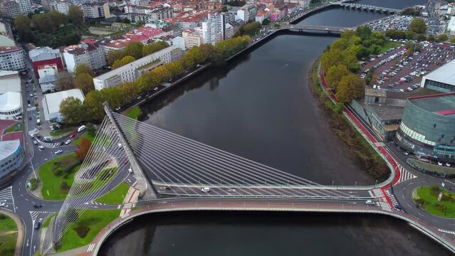 Cinematic aerial perspective of Pontevedra city. Drone going backwards and tilt up revealing the downtown of the city. Famous travel destination in Galicia. River Lerez and Puente de Los Tirantes
