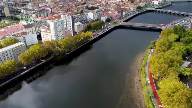 Cinematic aerial perspective of Pontevedra city. Drone going forward and tilt up revealing the downtown of the city. Famous travel destination in Galicia. River Lerez.  Bridges over the river.