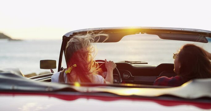 Women on road trip with car, ocean sunset and relax with freedom, nature and wind with excited view. Happy travel friends in convertible on adventure, journey and beach with sunshine on horizon.