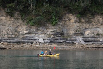 Unrecognizable couple riding on kayak on river