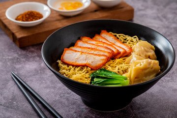 Egg noodle with red roasted pork and wonton in black bowl