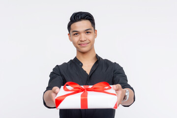 A handsome male suitor handing a white gift during valentines or anniversary. Wearing black polo...