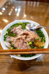 Pho Bo, famous Vietnamese soup noodle dish in street food restaurant in Hanoi, Vietnam