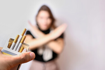 The girl is offered a cigarette, but she refuses, gesturing. The concept of the bad habit of...