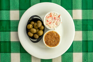 Delicious assortment of olives, farinheira pâté, and seafood pâté on a restaurant table.