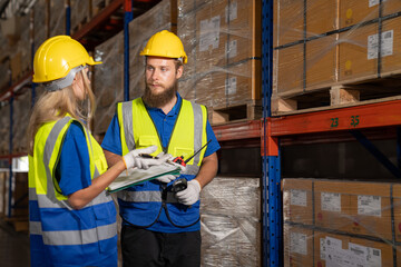 Two professional female and male warehouse checks stock workers, International car parts, import-export, and logistic business concepts: transportation, distribution, industry factory concept.