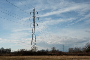 High-voltage direct current transmission. High voltage structures in the open field. Electric power line with blue sky in background.