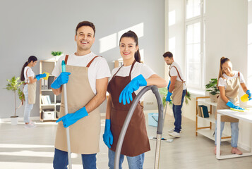 Male, female cleaners posing, group working, professional janitor service busy completing cleaning...