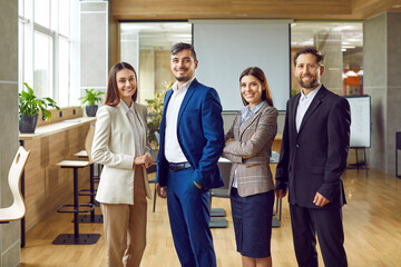 Diverse and positive group of young business people comes together for a team portrait in the...