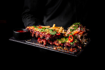 chef or waiter hold Pork ribs with french fries and coleslaw salad