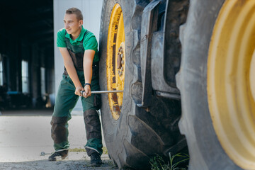 Fototapeta na wymiar Young mechanic repair tractor outdoor 