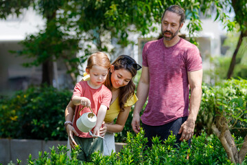 Fototapeta premium Father, mother and son, Caucasian family Planting trees and watering the garden