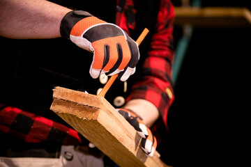Handwerker markiert Holzleiste mit Bleistift