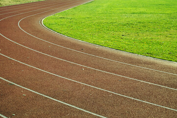 Running tracks in the stadium, detail of a running track with green grass

