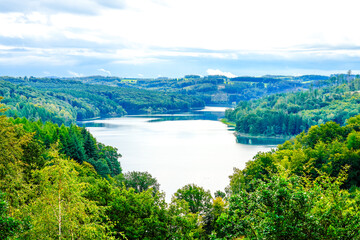 View of the Wiehltalsperre and the surrounding green nature. Idyllic landscape by the lake in the nature reserve near Reichshof in North Rhine-Westphalia.
 - obrazy, fototapety, plakaty