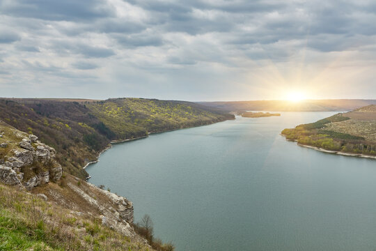 banks of a large river. Bakota, Dniester river, Ukraine. Smooth calm water panoramic landscape. High banks, green hills. Summer day in Eastern Europe.