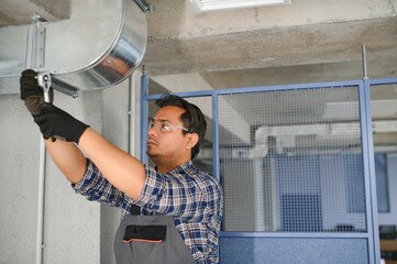 Fototapeta na wymiar specialist cleans and repairs the wall air conditioner