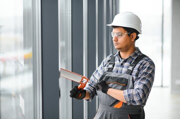 The worker installs a window frame in the room