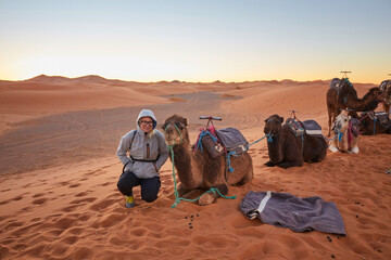 Fototapeta premium Tourists riding camels, smiling, in the Sahara Desert