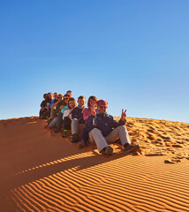 A group of tourists explores the majestic sand dunes of the Sahara Desert