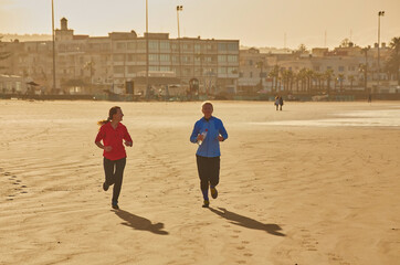 Two young woman embraces the tranquility of a seaside run along Essaouira's ocean
