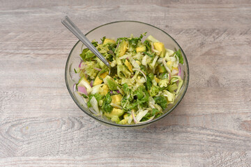 Fresh green vegetable salad in a glass bowl. Vegetarian food salad. Concept of a healthy diet. on a wooden table.