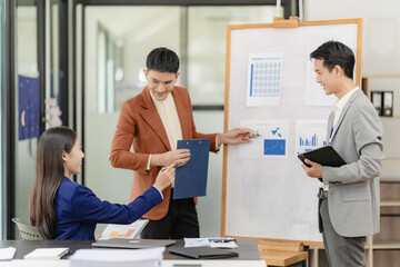 Team of successful Asian businessmen in suits working in conference room to discuss brainstorming,...