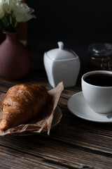 Morning with a cup of coffee and croissants. on a dark wooden background. Breakfast.