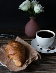 Morning with a cup of coffee and croissants. on a dark wooden background. Breakfast.