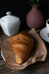 Morning with a cup of coffee and croissants. on a dark wooden background. Breakfast.