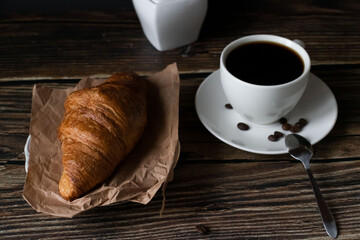 Morning with a cup of coffee and croissants. on a dark wooden background. Breakfast.