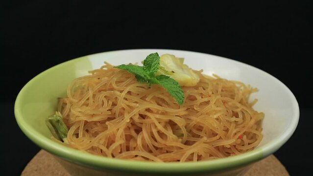 Bihun goreng, fried bee hoon, mee hoon, or rice vermicelli with vegetables and chili. A food with delicious, spicy and sweet taste on rotating display