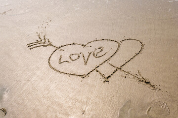 drawing in sand in form of two hearts and inscription love
