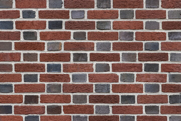 brick wall in flemish bond pattern with short side headers in black and long side stretchers in red, background