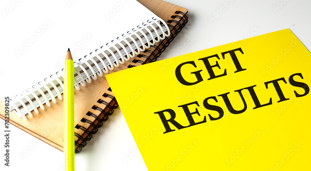 Poster get results text written on a yellow paper with notebook