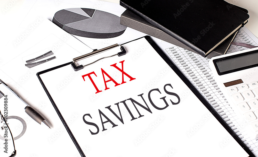 Poster tax savings text on paper clipboard with chart and notebook on withe background