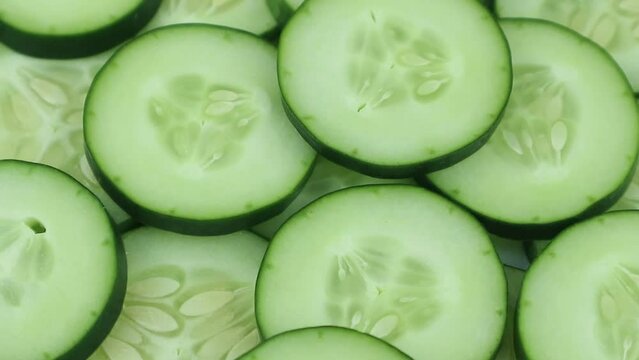 Cucumber slices top view, rotation. Background of chopped cucumber slices for cooking show, restaurant, cafe, fast food