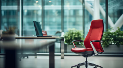 Red office chair placed in front of the table with laptop. Modern workspace or workplace interior design where employees are coming to their job, indoors remote internet connection corporate work