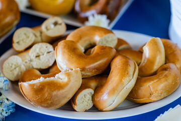 close up of sliced halved plain bagels on a platter