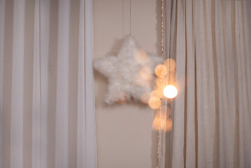 Points of light with a hanging star and curtains in the background, cozy room
