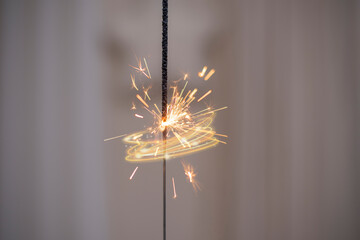 Sparkling sparkler with star and curtain in the background