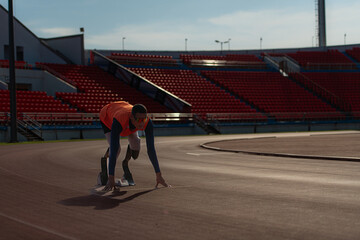 Disabled athletes prepare in starting position ready to run on stadium track