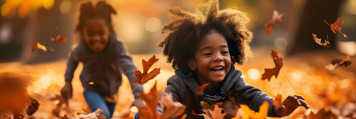 black kids playing in autumn leaves on a sunny day - obrazy, fototapety, plakaty