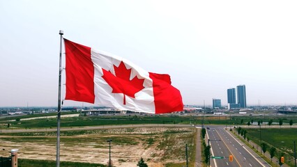 Flag of Canada on sky background in close-up fluttering in wind symbol of national borders freedom...