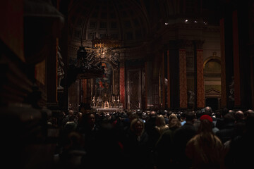 Witness the quiet reverence as people gather along the church aisle for a service in London. The...