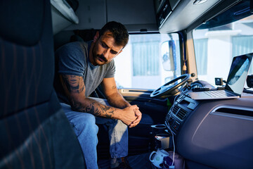 Pensive truck driver sitting alone in vehicle cabin.