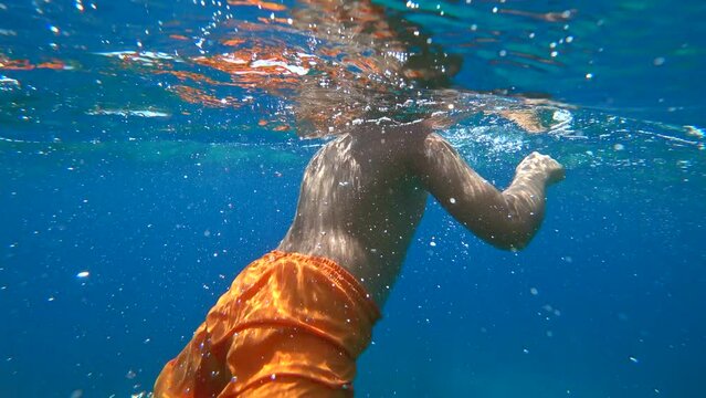 Kas, Turkey - 5th of September 2023: 4K Chubby boy tumbling backwards underwater
