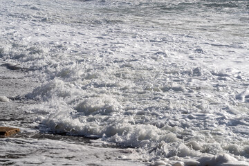 white sea foam near the shore close-up, waves