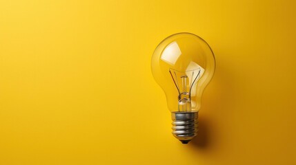 Light bulb on yellow background with copy space - obrazy, fototapety, plakaty